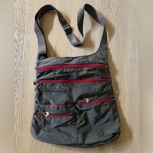 Travelon green with red zipper crossbody travel bag with multiple pockets